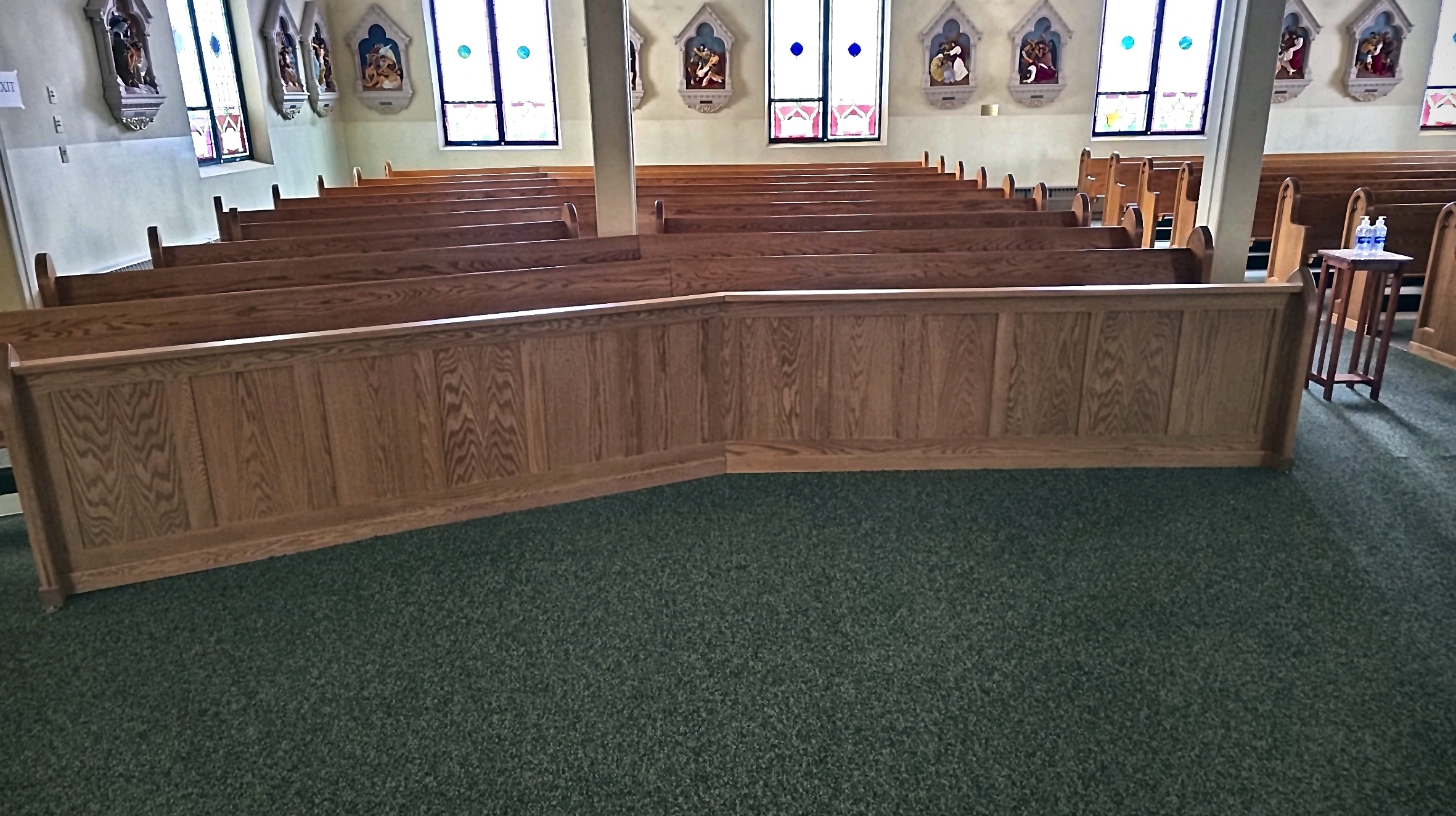 Wooden pews and interior millwork beneath stained-glass windows