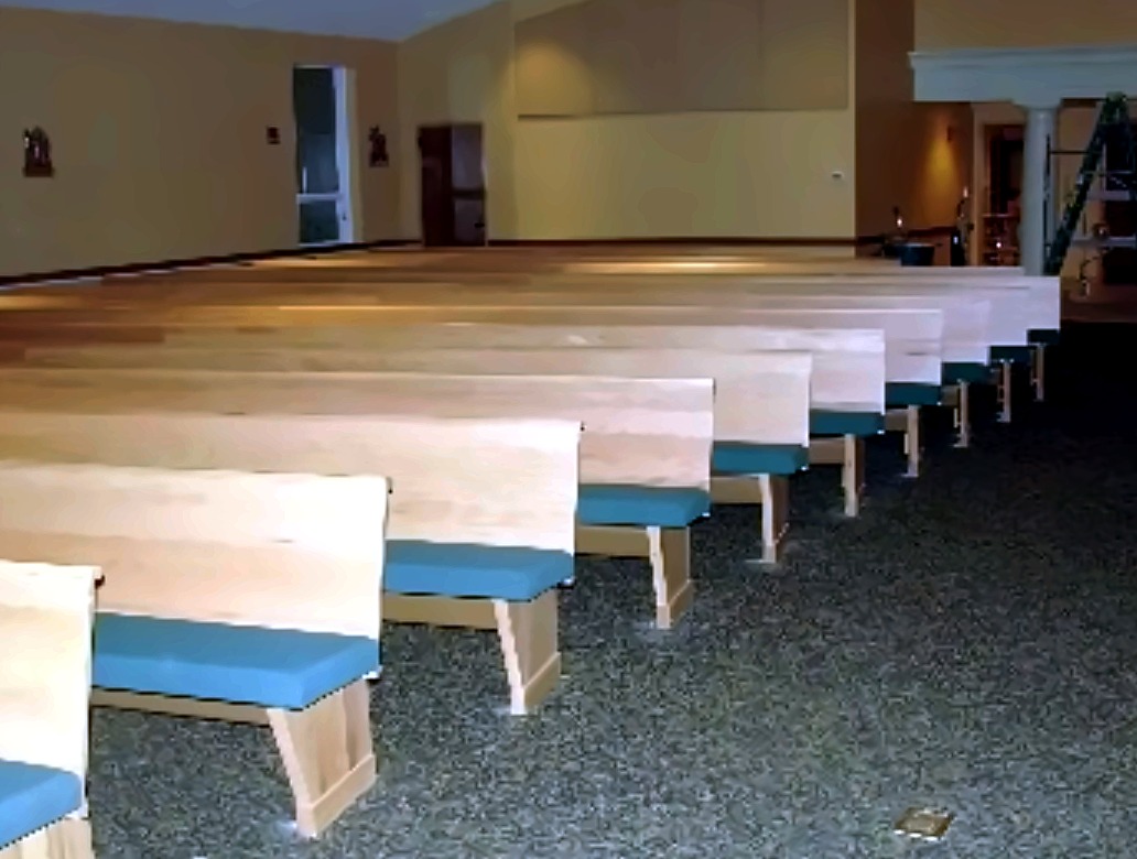 Rows of custom church seating in a finished interior